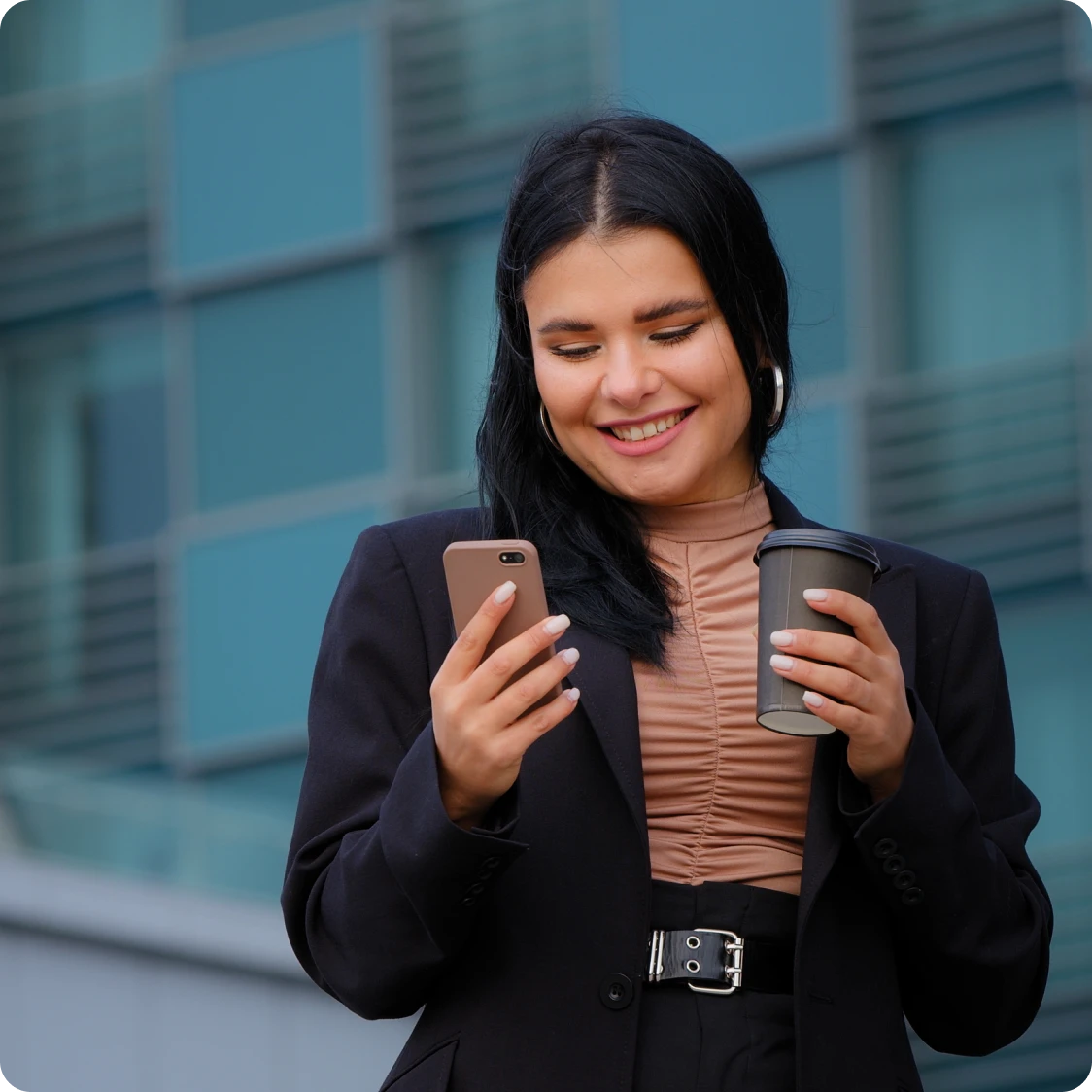 chica caminando con un café mirando su celular