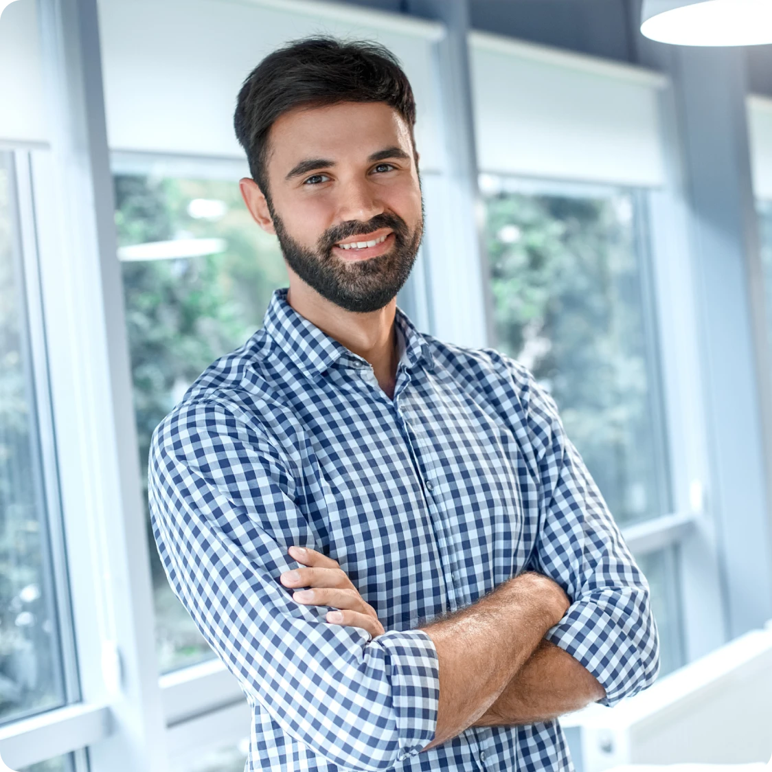 hombre sonriendo con los brazos cruzados