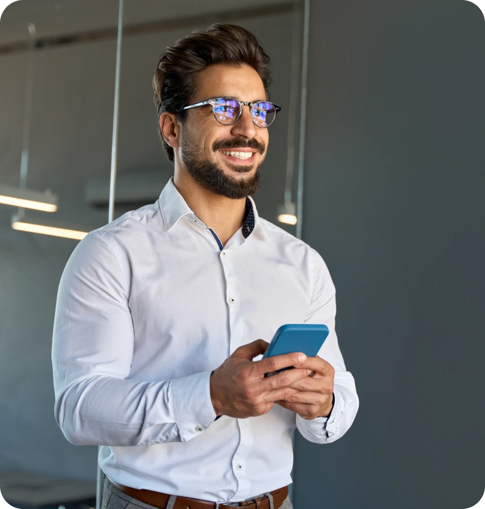un hombre sonriendo sujetando su celular