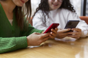 Equipo de profesionales comparando opciones de WhatsApp Business y API en sus dispositivos móviles